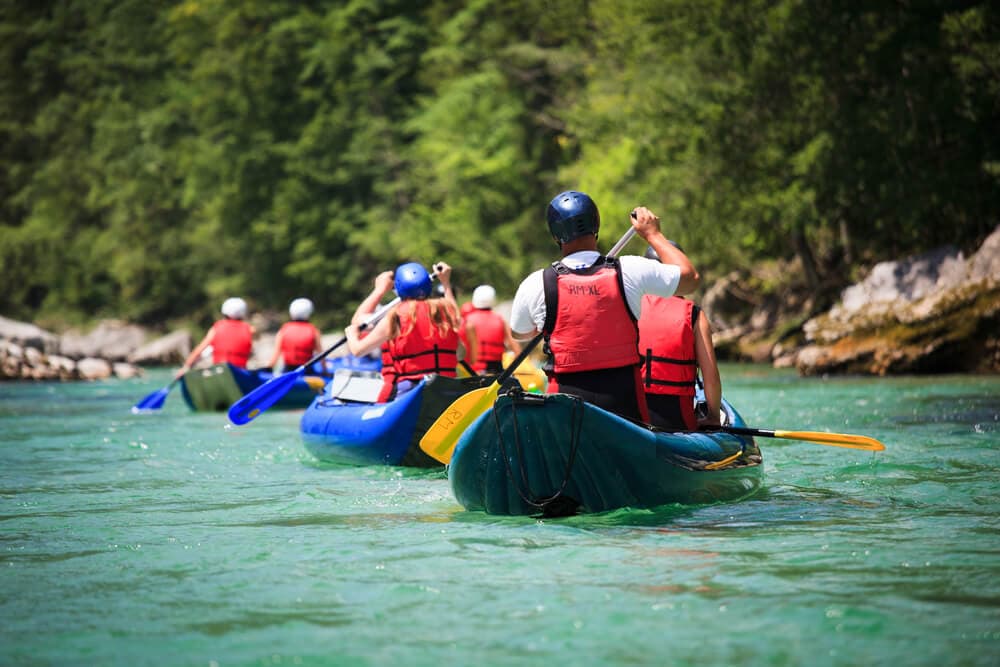 17 Best White Water Rafting Vancouver Tours (2024) 5 A couple of 2-person white water rafts rowing on a calm river in Vancouver.