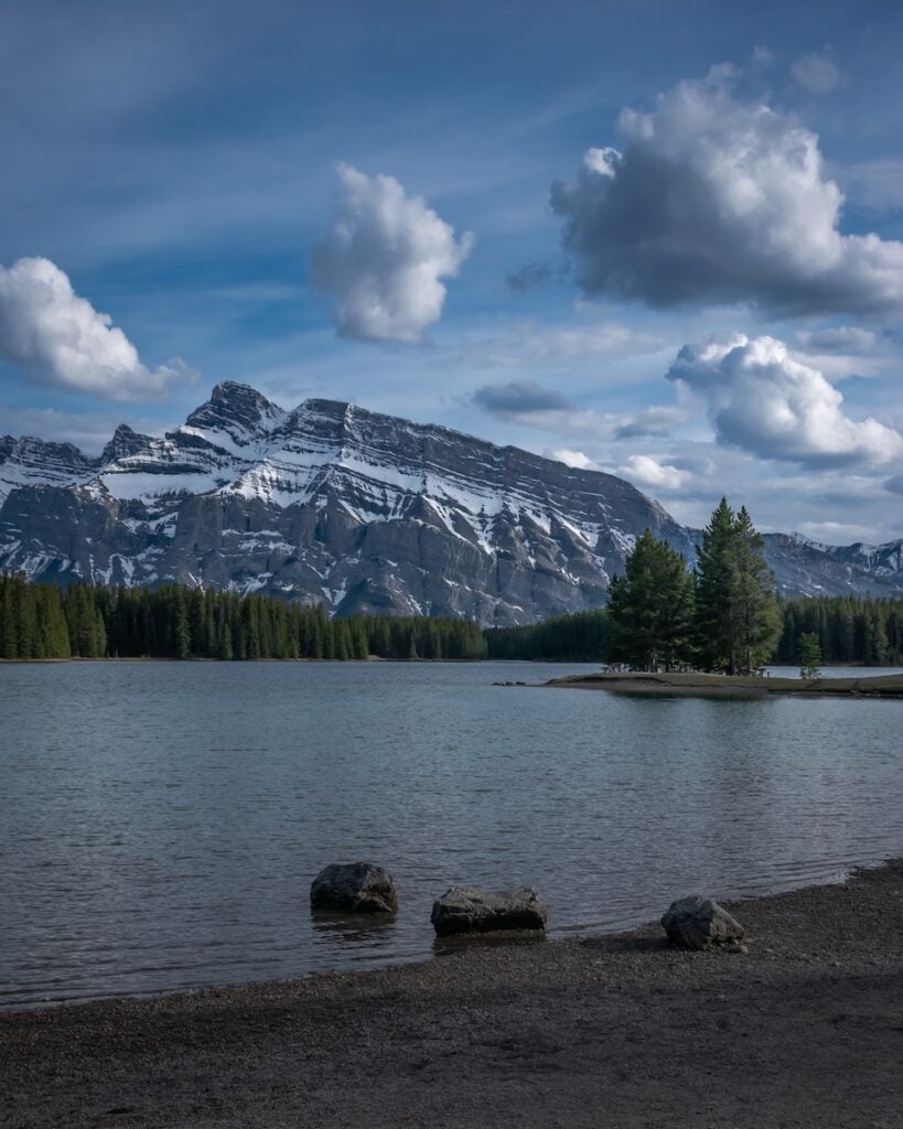 Banff National Park Itinerary: 1, 3, and 5 Day Guides 18 View from the shore of Two Jack Lake in Banff that captures trees and mountains - a great stop if you have more time on your Banff National Park itinerary.