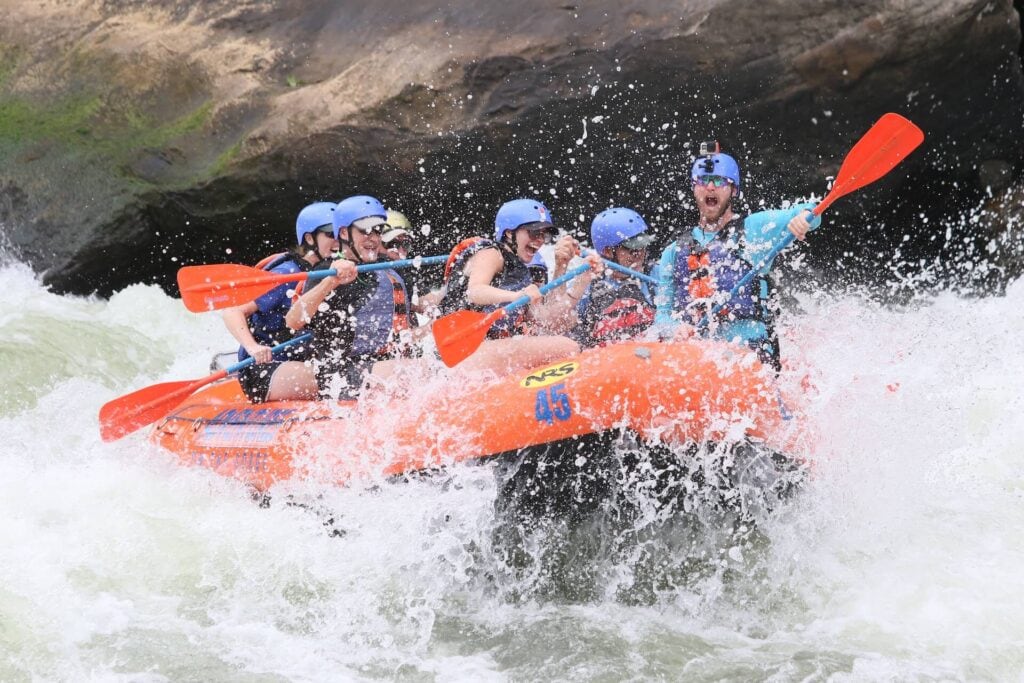 15 Best Quebec White Water Rafting Tours 4 A group of friends river rafting while screaming and enjoying the strong river currents of the Rouge river.