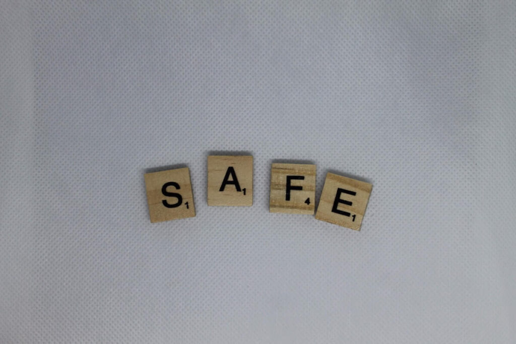 16 Pros and Cons of Living in Iowa 2024 2 Wood scrabble tiles saying "SAFE" above a white cloth in Iowa - safety is definitely one of the big pros of living in Iowa.