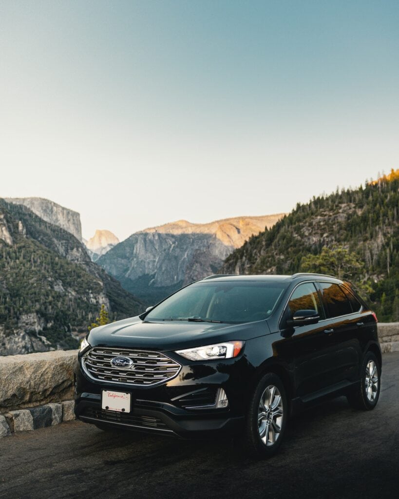 15 Best Niagara Falls Tours from Toronto (2024) 6 A black SUV on a road near the mountains with green trees. This is the ride for the Private SUV Niagara falls Tour from Toronto.