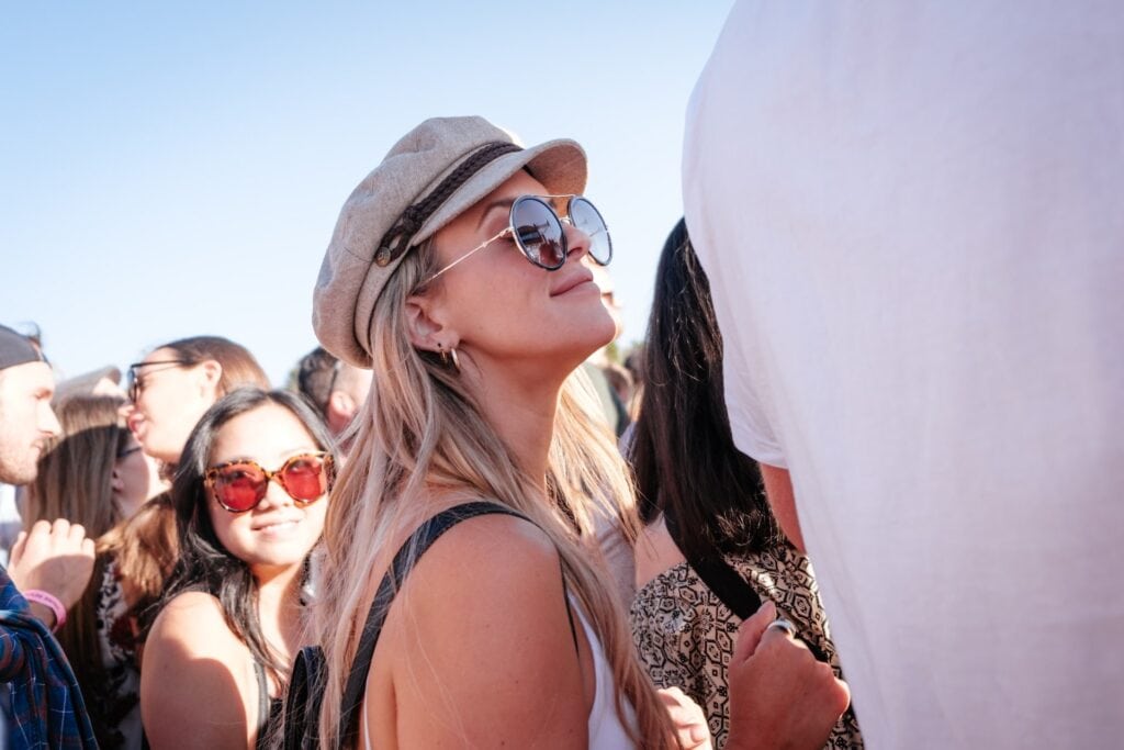 23 Best Reasons to Be Living in Melbourne in 2024 4 A woman with a beret and sunglasses is one with the crowd. This is during a festival in Melbourne