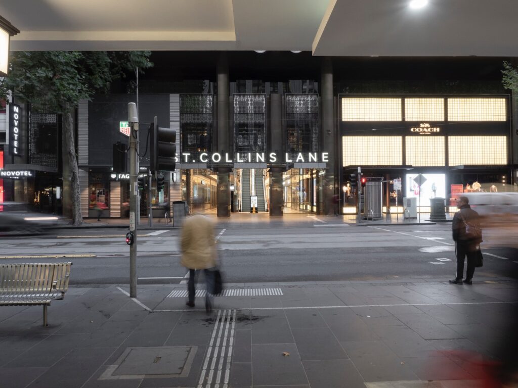 23 Best Reasons to Be Living in Melbourne in 2024 8 Woman in White Coat Walking on a Sidewalk in Melbourne.