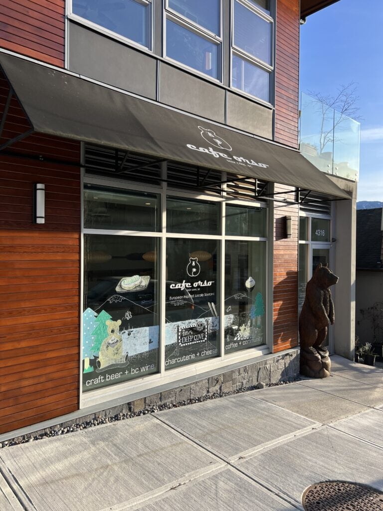 23 Best Things to Do in Deep Cove, BC 2024 16 Cafe Orso exterior with a wooden bear out front of the cafe.