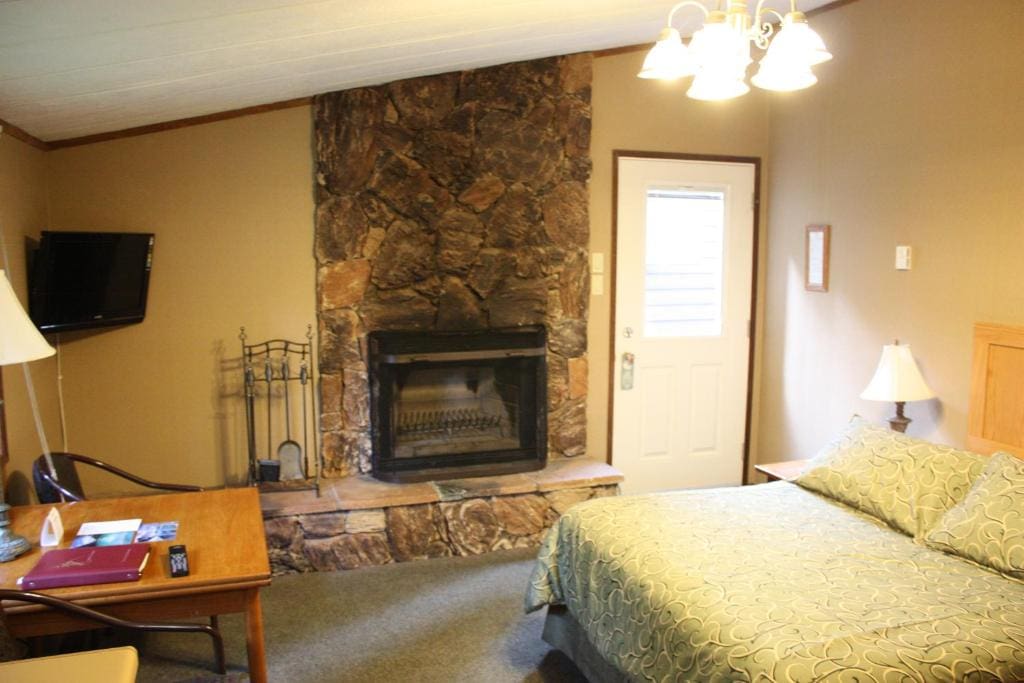 Where to Stay Near Jasper National Park: 16 Best Hotels 14 A comfortable bed with white sheets inside a room with beige walls. A fireplace can be seen beside the bed nea a desk and a chair. This iis in Sunwapta Falls, one of the best places to stay in Jasper National Park.