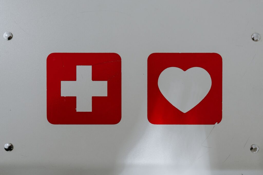 Living in Prague: The Complete Expat Guide (2024) 6 A white signboard with a cross icon and a heart icon. One of the best things bout lving in Prague is that it's one of the safest cities in Europe.