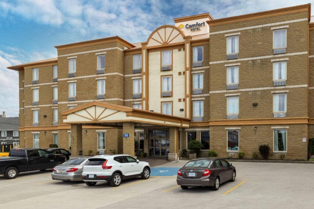 Where to Stay in Halifax: 17 Best Hotels in 2024 17 A brown bricked building with a long concrete canopy on the first floor. Several cars are also parked in front of the building. This is the entrance of the Comfort Hotel, one of the best places to stay in Halifax