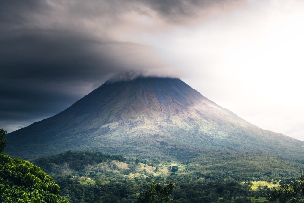 25 Pros and Cons of Living in Costa Rica in 2024 8 Volcano in Costa Rica with clouds covering the top of the mountain.