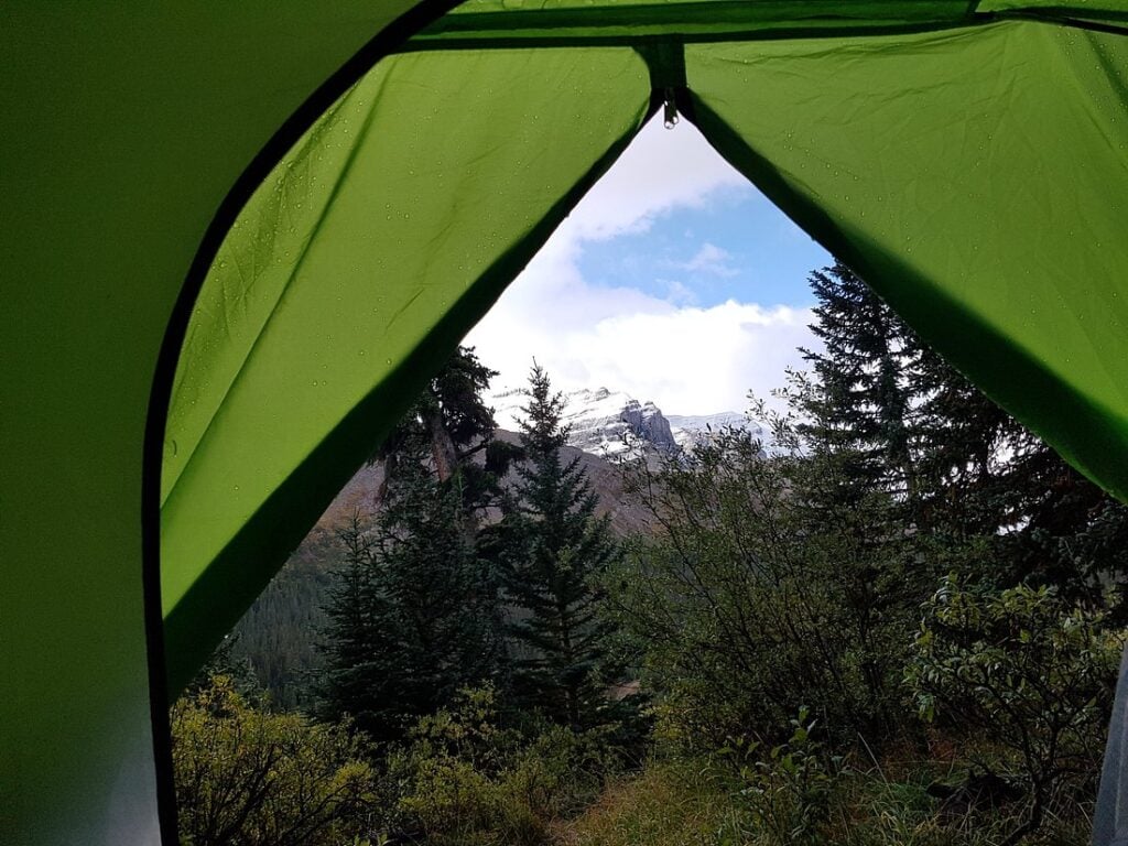Where to Stay Near Jasper National Park: 16 Best Hotels 19 A photo of the view from inside the green tent facing large trees in the forest. One of the best places to stay in Jasper national Park is the Columbia icefields Campground whereyou can be one with nature.