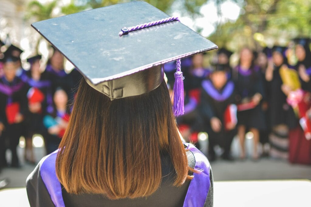 27 Pros and Cons of Living in Tennessee in 2024 6 A girl with brown hair with back towards the camera, wearing a toga and a graduation cap. Through Tennessee's Promise Program, many students can receive quality education.