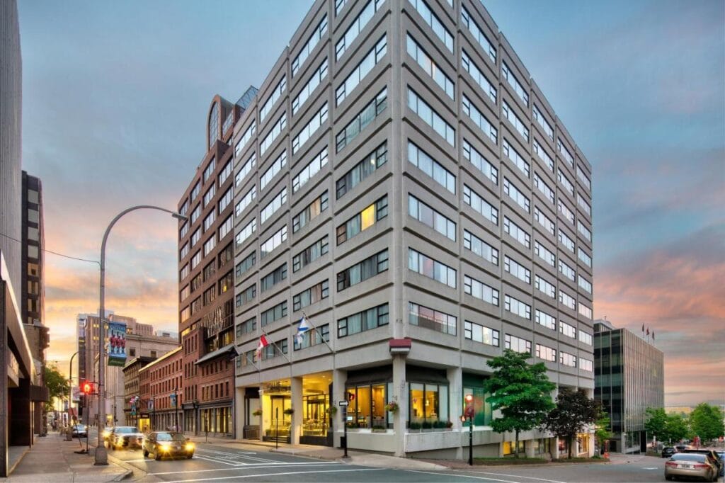 Where to Stay in Halifax: 17 Best Hotels in 2024 8 A photo of a large brown building with large windows on each floor. It is strategically built on a corner of a street where many cars and people pass by. This is the Hollis Halifax, one of the best options if you're wondering where to stay in Halifax.