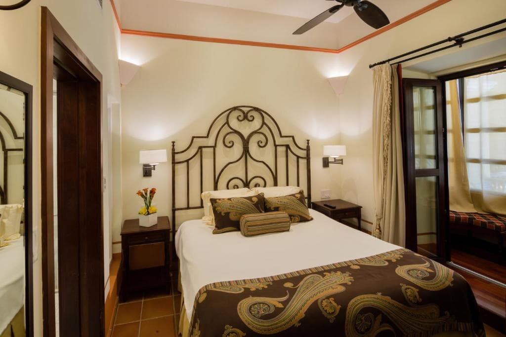 13 Best Hotels in Old San Juan, Puerto Rico 2024 9 A single bed withwhite and brown-patterned sheets with two bedside tables and lamp on both sides. This is one of the rooms in the Hotel El Convento, a hotel in old San Jan.