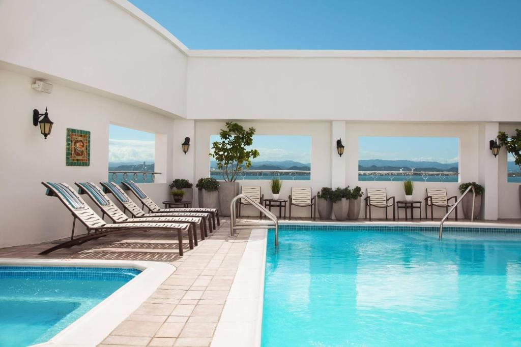13 Best Hotels in Old San Juan, Puerto Rico 2024 13 A rectangular shaped indoor pool with four bathing chairs lining up beside it. A hot tub can also be seen beside the pool. This is in Sheraton Hotel one of the best luxury hotels in San Juan, Puerto Rico.