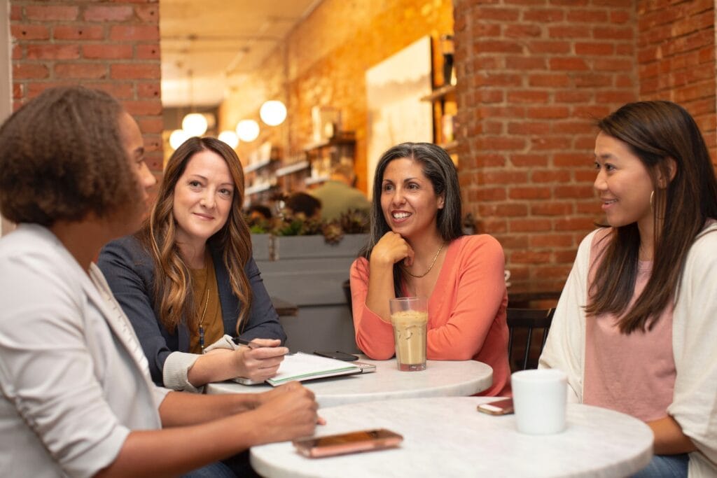 Living In Dublin 2024: The Complete Expat Guide 5 Four people sitting accross each other on a cafe. Gaelic is the widely used language for communication in Dublin.