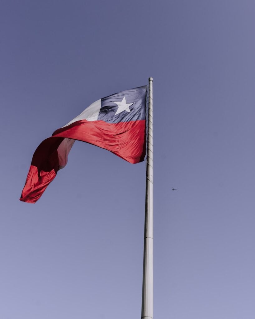 red and white flag on pole during daytime. The flag of Chile 