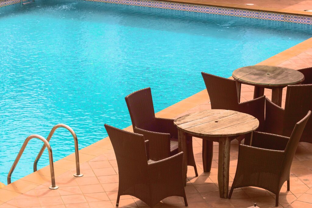 10 Best Hotels with Waterslides in Toronto 8 Two sets of chairs surrounding 2 round wooden tables beside the rectangular shaped pool. The Sandman Signature Mississauga Hotal has an indoor pool with a huge 3-storey waterslide.