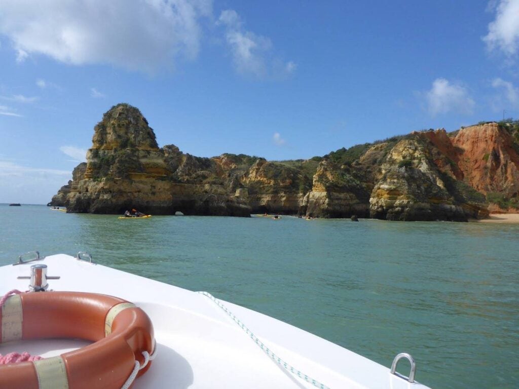 33 Living in Portugal Pros and Cons from an Expat 2 Algarve beach from a boat in Portugal. View of the golden cliffs over turquoise water
