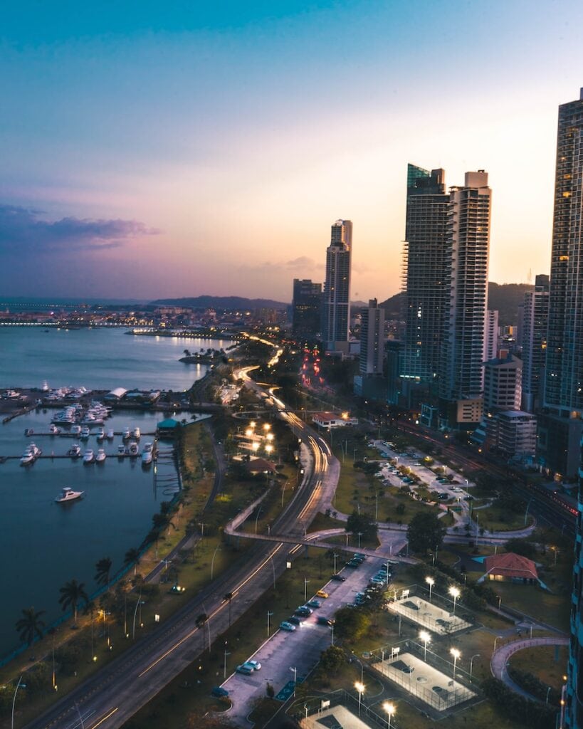 35 Pros And Cons Of Living In Panama In 2024 1 high rise buildings near body of water in distant of mountain in Panama at sunset