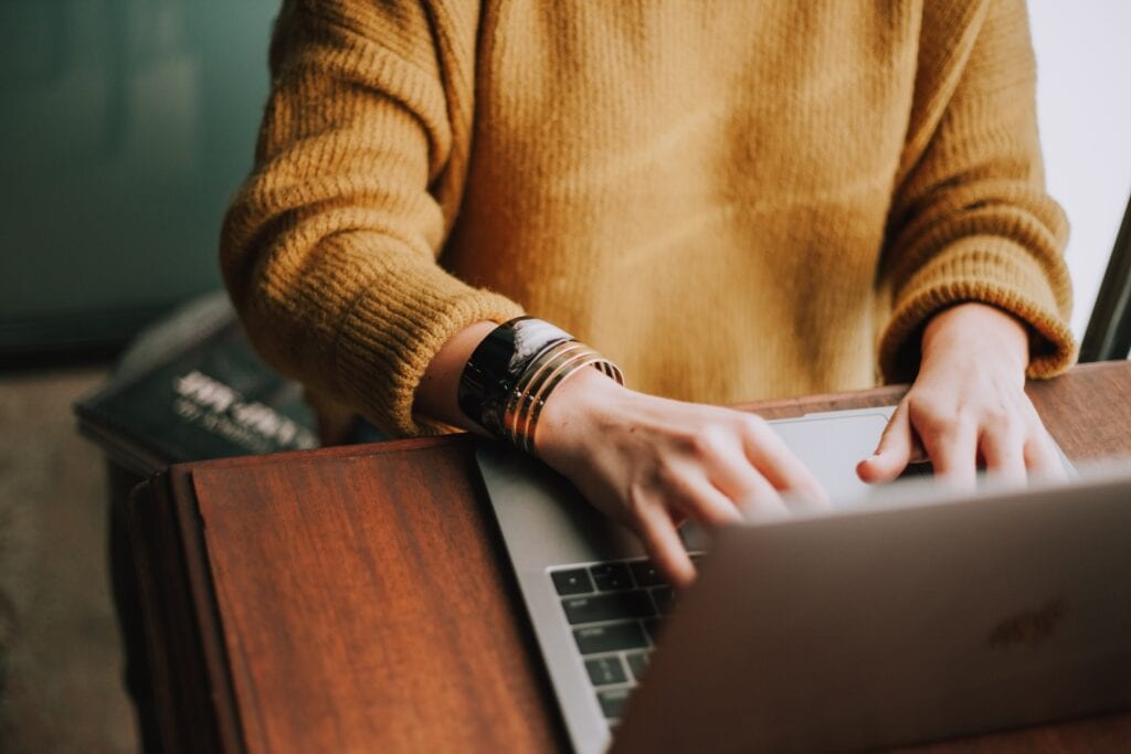 25 Pros and Cons of Living in New Hampshire in 2024 3 A person in a yellow jacket using their laptop aboce a wooden table. In New Hampshire, there are a lot of job opportunities.