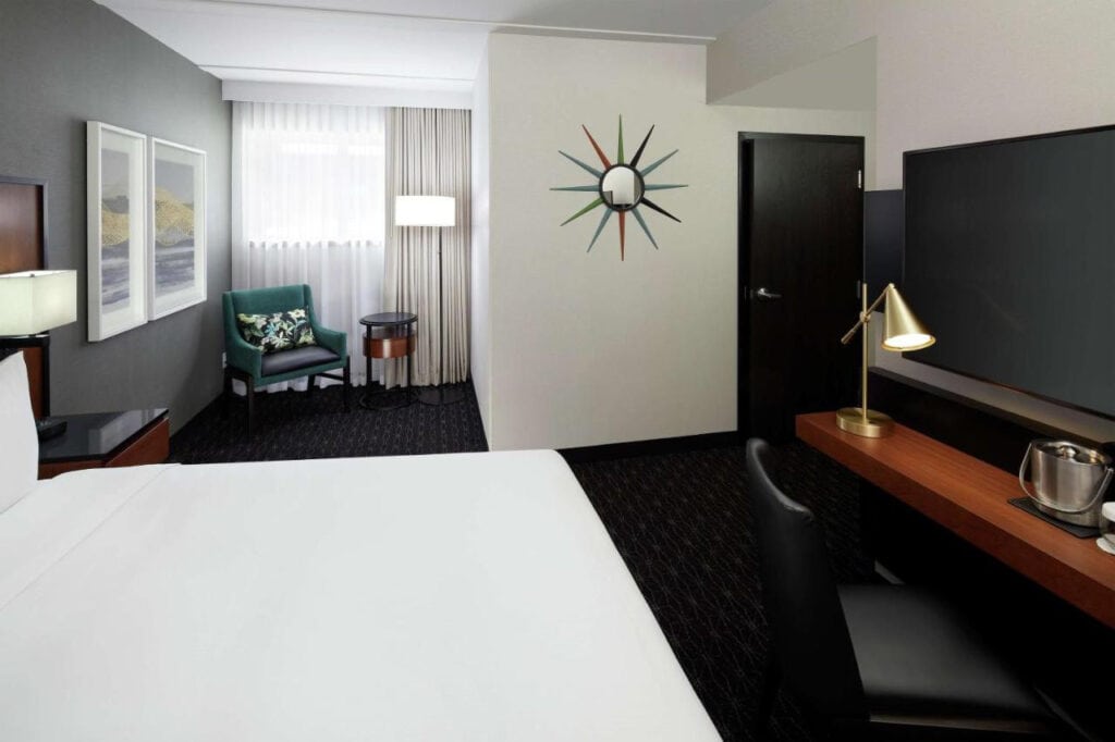 22 Best Places to Stay in Montreal Canada 24 A large white-walled room with a large King size bed inside. A television can be seen beside the bed and above a wooden sleek dresser. This is in the Doubletree by Hilton in Montreal Canada.