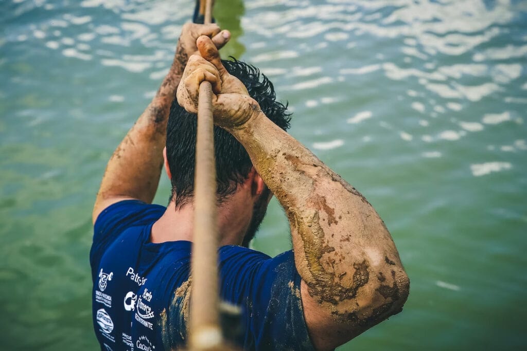 17 Best Day Trips From Niagara Falls (2024) 8 A man wearing a blue shirt holding tightly on a rope above his head, and looking down a body of water. The Adventure Ropes Course in Niagara Falls is one of the most thrilling ways to experience the falls.