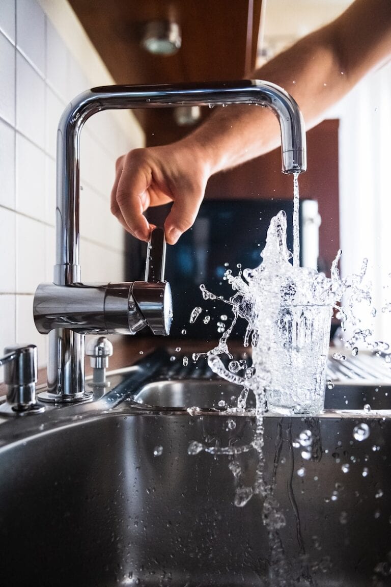 Is It Safe To Drink Tap Water In Toronto? (2024 Guide) 1 person opening faucet to pour water into a glass in Toronto