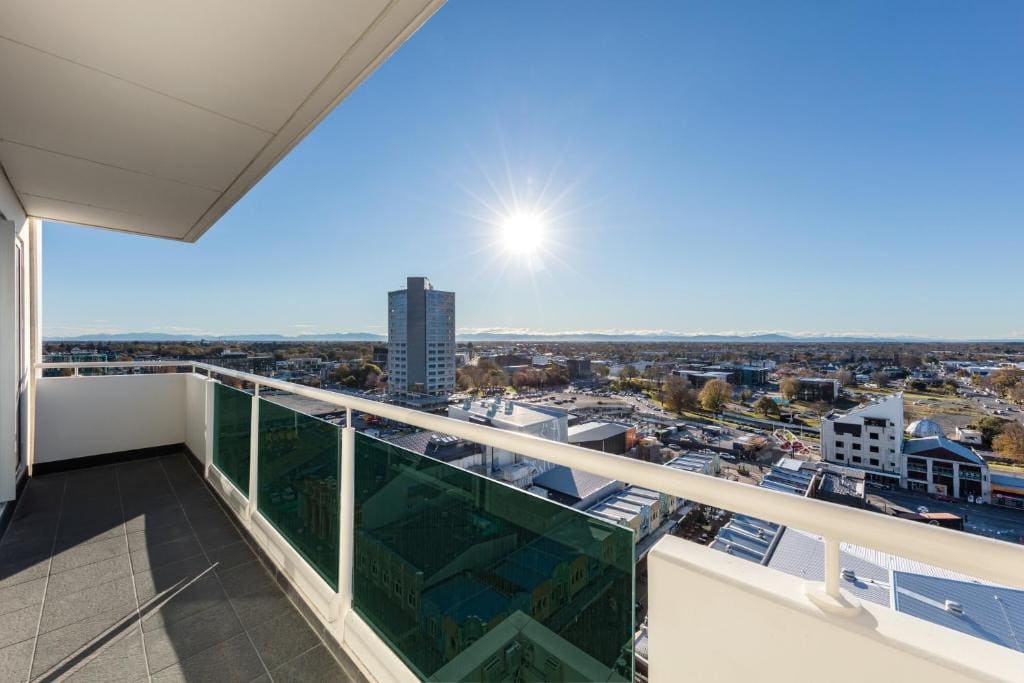 18 Best Hotels in Christchurch, New Zealand 2024 6 A balcony with tiled floorings and a glass and metal railings offering a view of a beautiful city during the day time. This is in the fable Christchurch Hotel