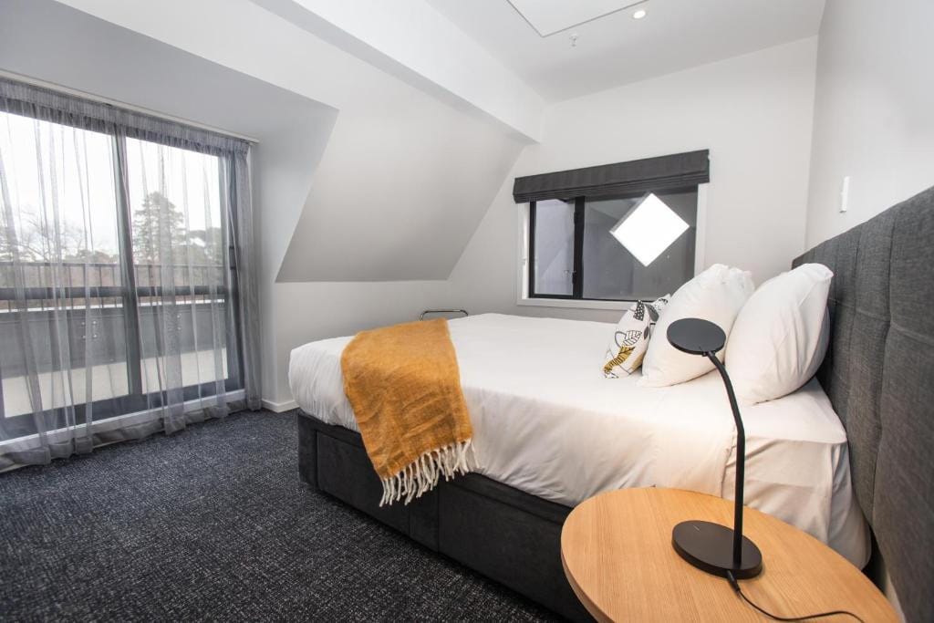 18 Best Hotels in Christchurch, New Zealand 2024 15 A bed facing a sliding door towards a balcony. This is in Hotel Give, Christchurch, New Zealand.