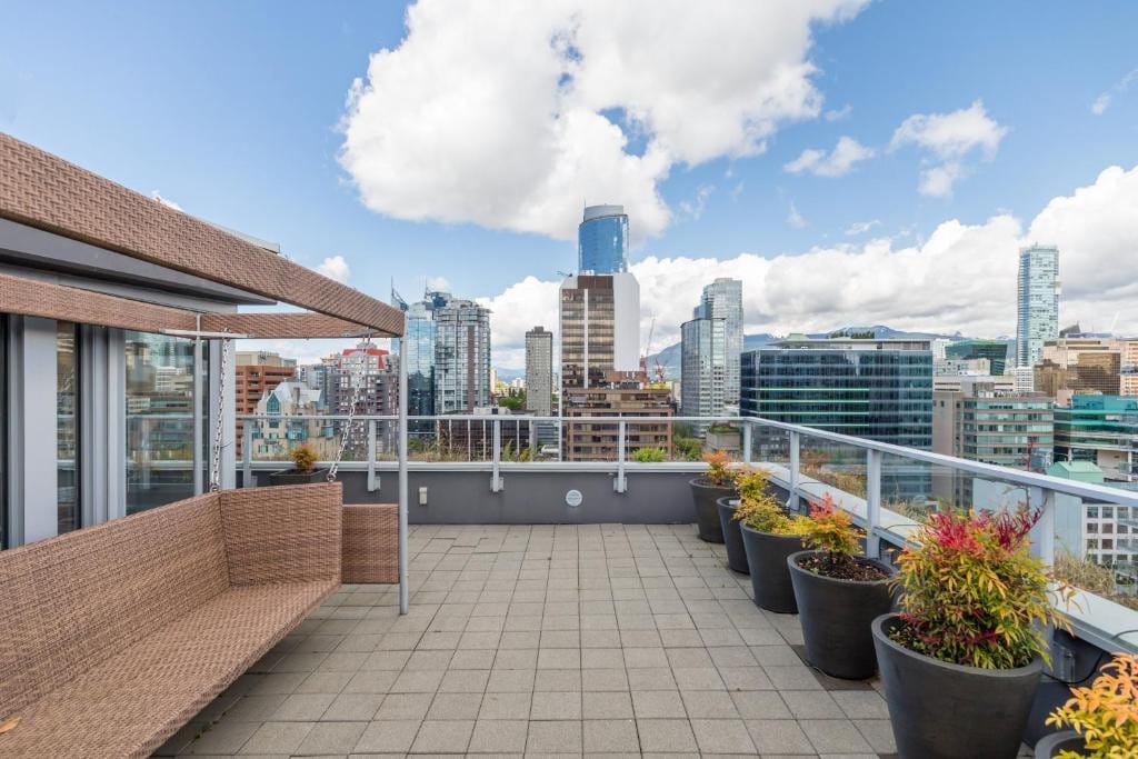 23 Best Vancouver Hotels with Balconies (A Local’s Guide) 17 A balcony with tiled flooring and metal railings. A rattan bench can also be seen. This is in Level Yaletown, Vancouver.