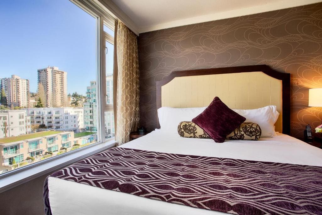 23 Best Vancouver Hotels with Balconies (A Local’s Guide) 24 A large bed beside a huge window that offers stunning views of the city. This is in the Pinnacle Hotel at the Pier in Vancouver.