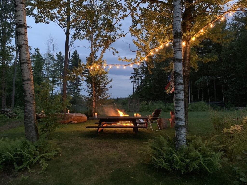 Why This World Traveler Chose to Live in Vermont Over All Other Places (Including Alaska!) 2 Heather's Backyard in Vermont. You can see fairy lights through the trees and a fire beside a picnic table as her family gathers around in the evening.
