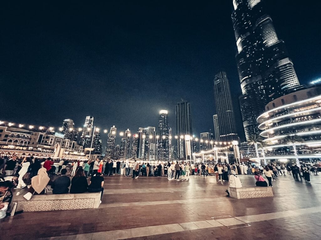 This Expat Left Teaching in Japan for Living in Dubai. Here's Why! 3 The Burj Khalifa area of Dubai with tall skyscapers at night and a lit up public square area.