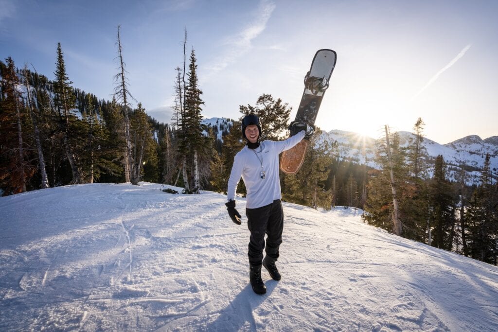 25 Pros and Cons of Living in Utah 2024 6 a man holding a snowboard