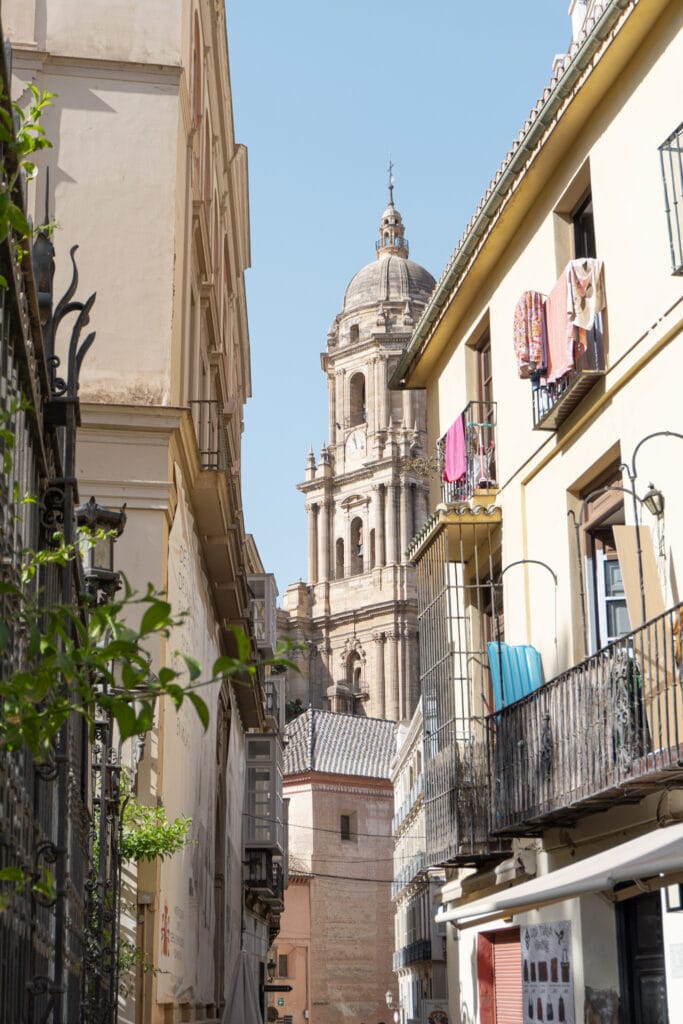Discover Life Beyond the Tourist Trails in Spain's Coastal Towns Through a Local's Eyes 5 Narrow street leading to the Malaga Cathedral, lined with traditional balconied homes.
