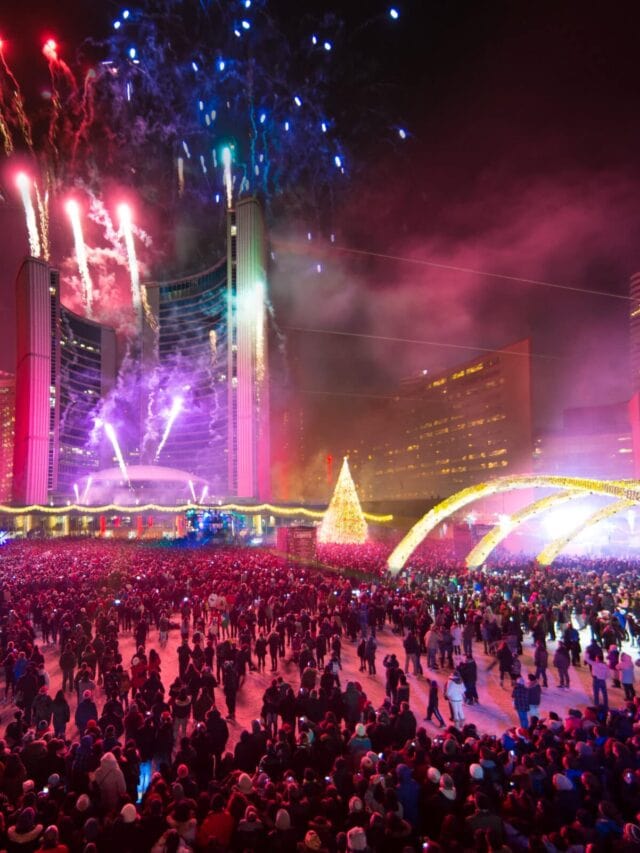 Best Time to Visit Toronto (A Month-By-Month Guide) 9 Festive lights, celebrations, and fireworks above large crowds of peope in Nathan Phillips Square