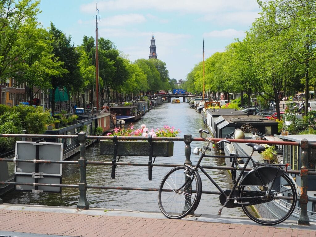 14 Top Freelance Visa Countries To Live And Work In 2024 9 A bike parked in the bridge by the river surrounded with trees in Amsterdam.