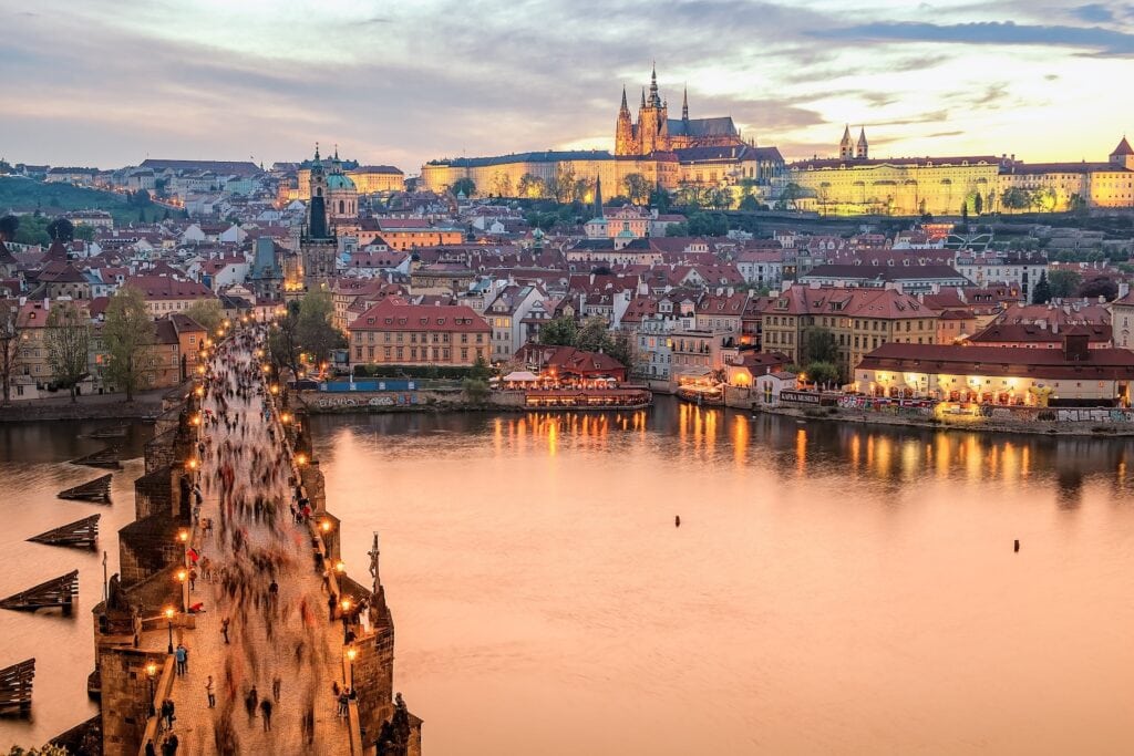 ALL European Countries With Digital Nomad Visas (2024) 5 A bridge going to the city full of lights during sunset at Czech Republic.