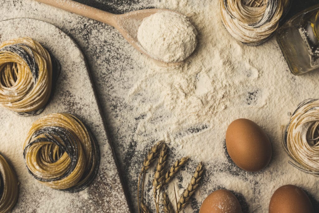 Things I Took For Granted Until I Moved to Italy 9 Homemade pasta ingredients on a kitchen counter in Italy. Spiral pasta, eggs, flour, and oil.