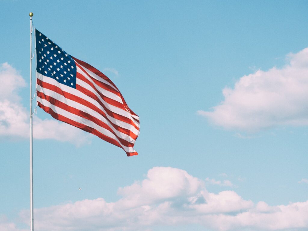 20 Reasons Not to Live in the US (2024) 18 An American flag on a pole waving.