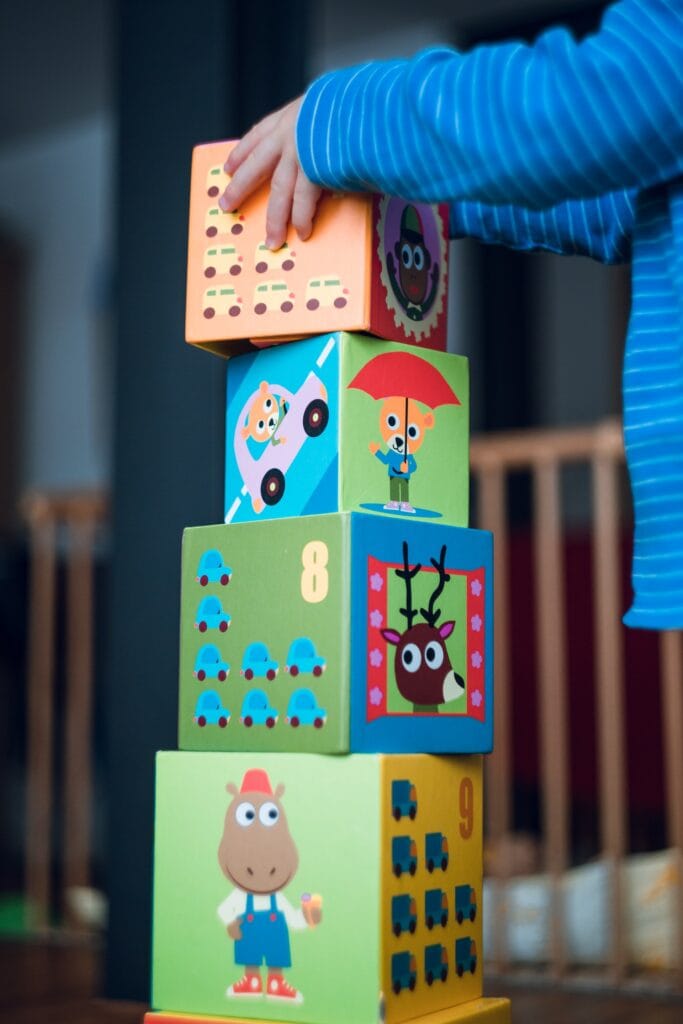 20 Reasons Not to Live in the US (2024) 10 A kid stacking gour toy cube blocks.