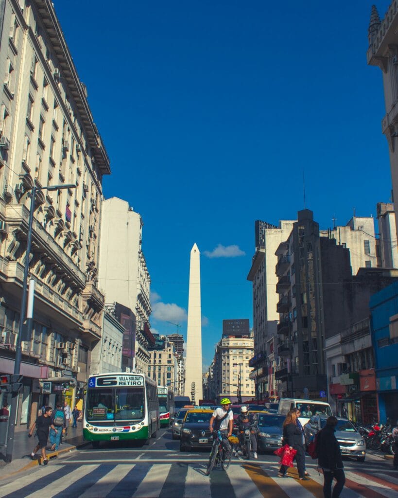 Top 17 Countries With Retirement Visas (2024 Guidelines) 9 A busy street in Argentina with public buses, lots of cars and people crossing a pedestrian lane.