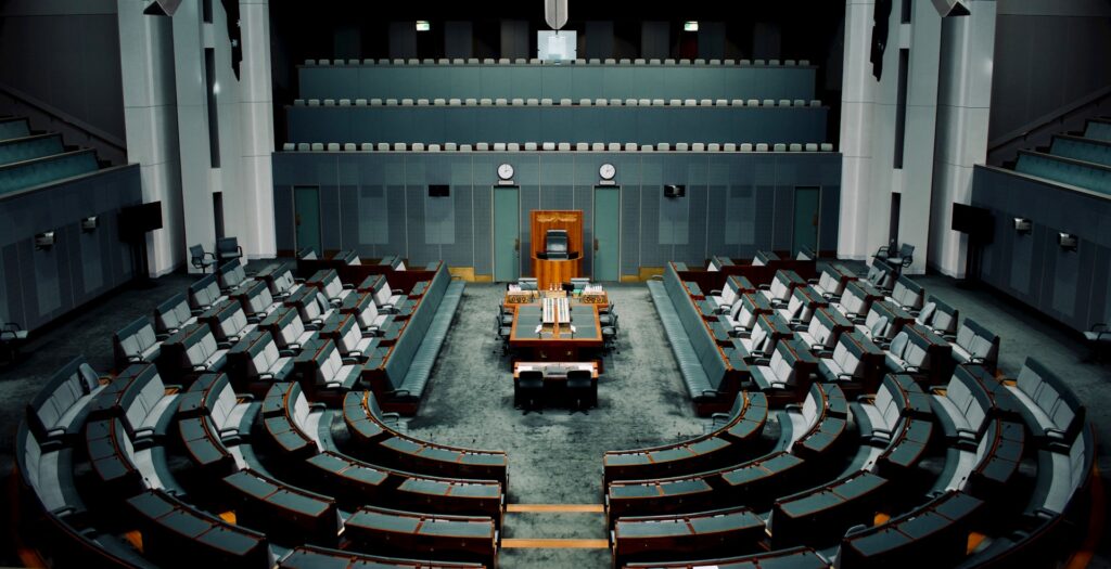 19 Reasons Not To Move To Australia In 2024 12 A government hall with a table and high wooden chair in the middle.