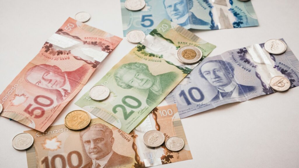 17 Pros and Cons of Retiring in Canada (From a Local) 3 Paper bills of Canadian dollar with some coins.
