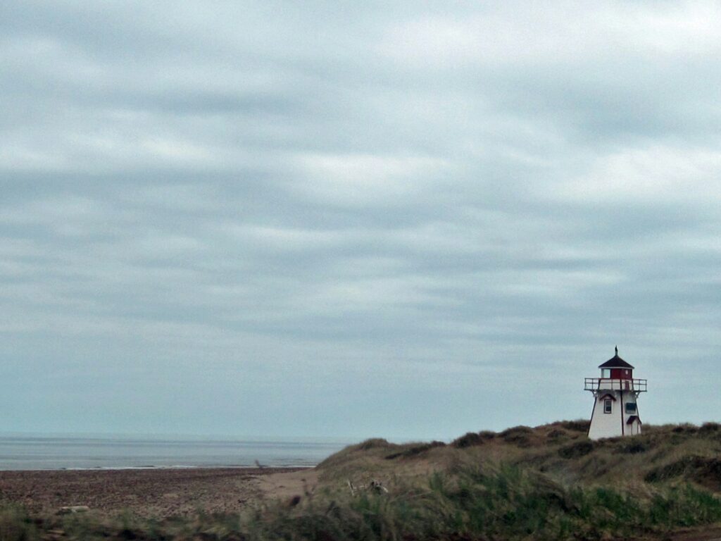 15 Best Places to Retire in Canada (From a Local Canadian!) 6 A lighthouse in a mountain beside the beach in Prince Edward Island,
