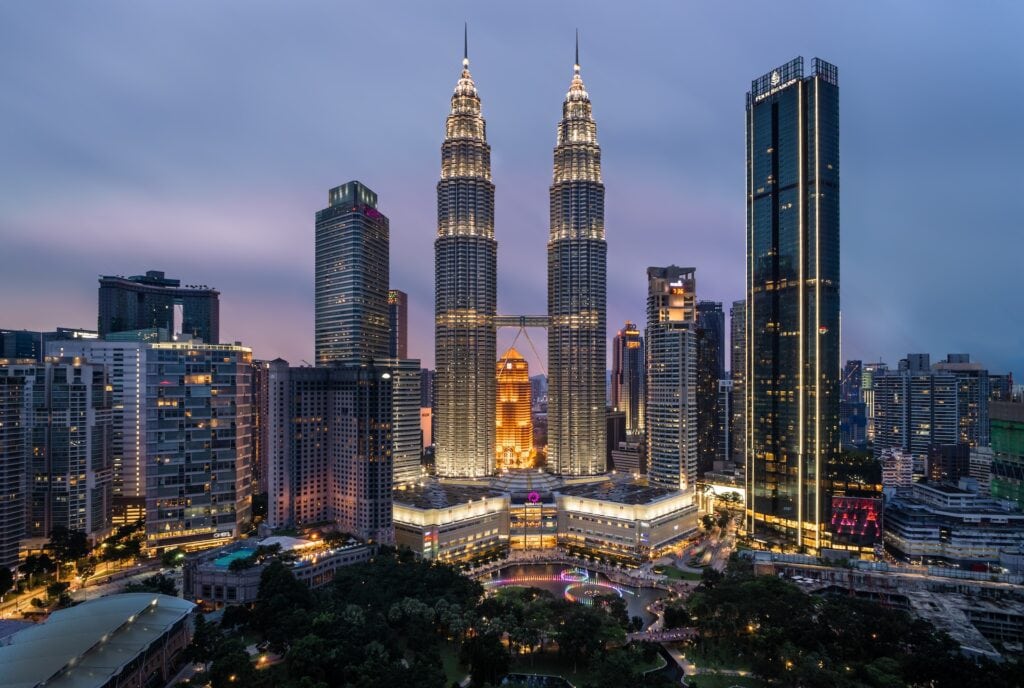 Top 17 Countries With Retirement Visas (2024 Guidelines) 13 Two identical tall towers light up at night in Malaysia.