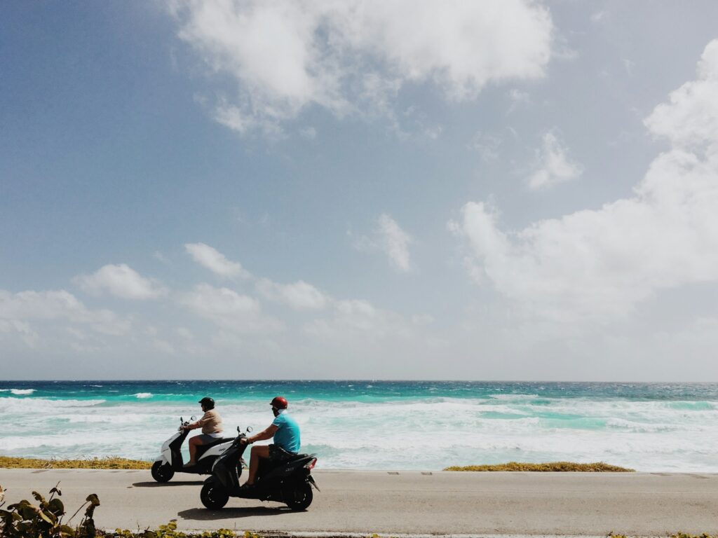 Top 17 Countries With Retirement Visas (2024 Guidelines) 3 Two people riding a motorcycle while driving by the beach in Mexico.