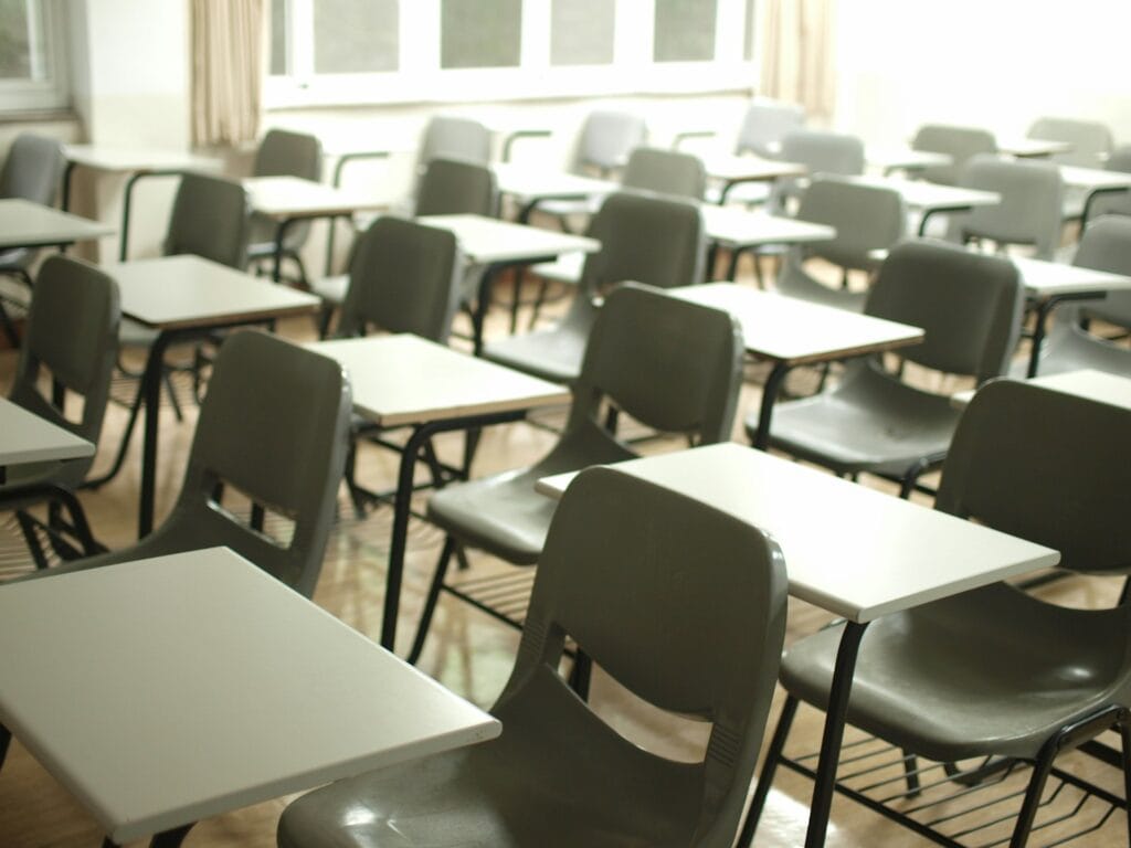 13 Countries That Will Pay You To Move There (Expat’s Picks) 8 A classroom with grey chairs and whote tables.