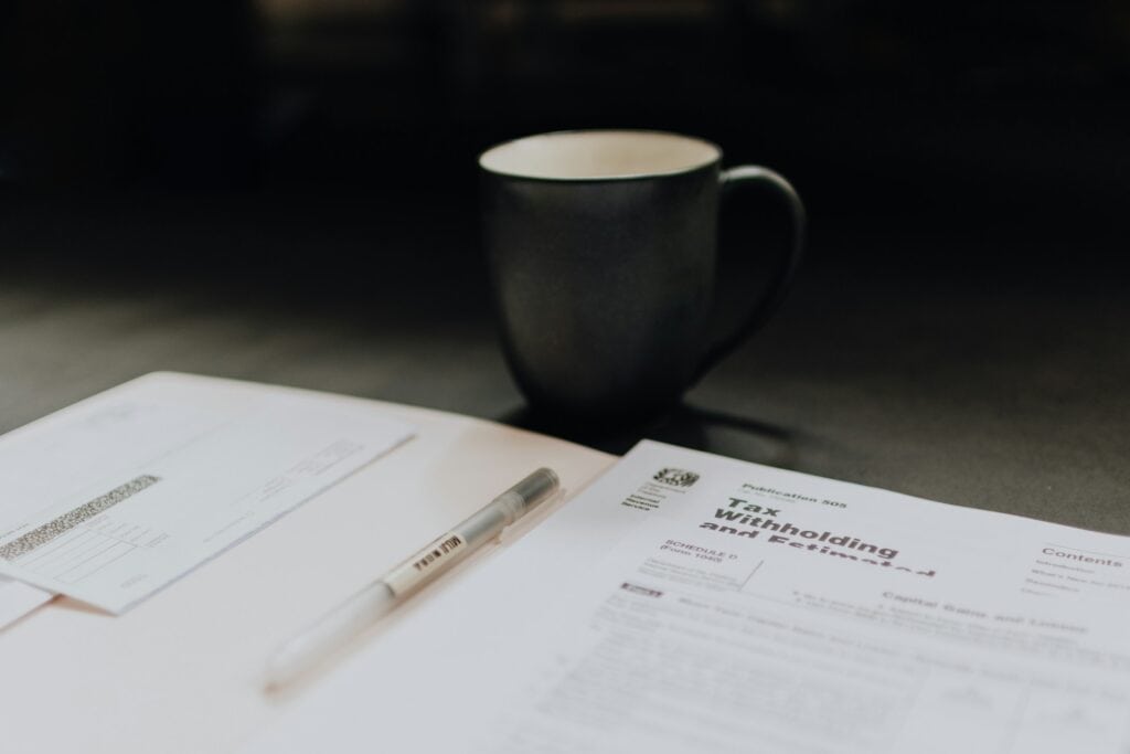New Zealand Paying People To Move There: 2024 Guide 5 A black coffe mug with tax papers.