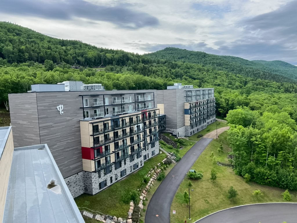 My 4 Day Charlevoix Itinerary to Recharge in Quebec 17 Modern multi-story Club Med resort buildings nestled in green forested hills with a winding road out front. This family-friendly hotel option is popular for adventure and relaxation.